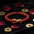 Red agate Pixiu wealth bracelet on dark velvet with gold coins
